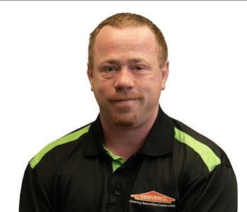 Employee in front of SERVPRO signage