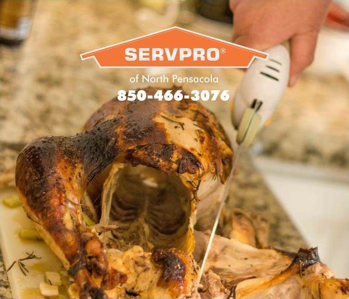 A man is shown using an electric knife to carve a turkey.