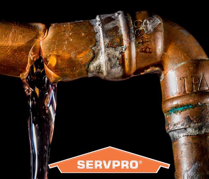 Pipe leaking water with SERVPRO logo